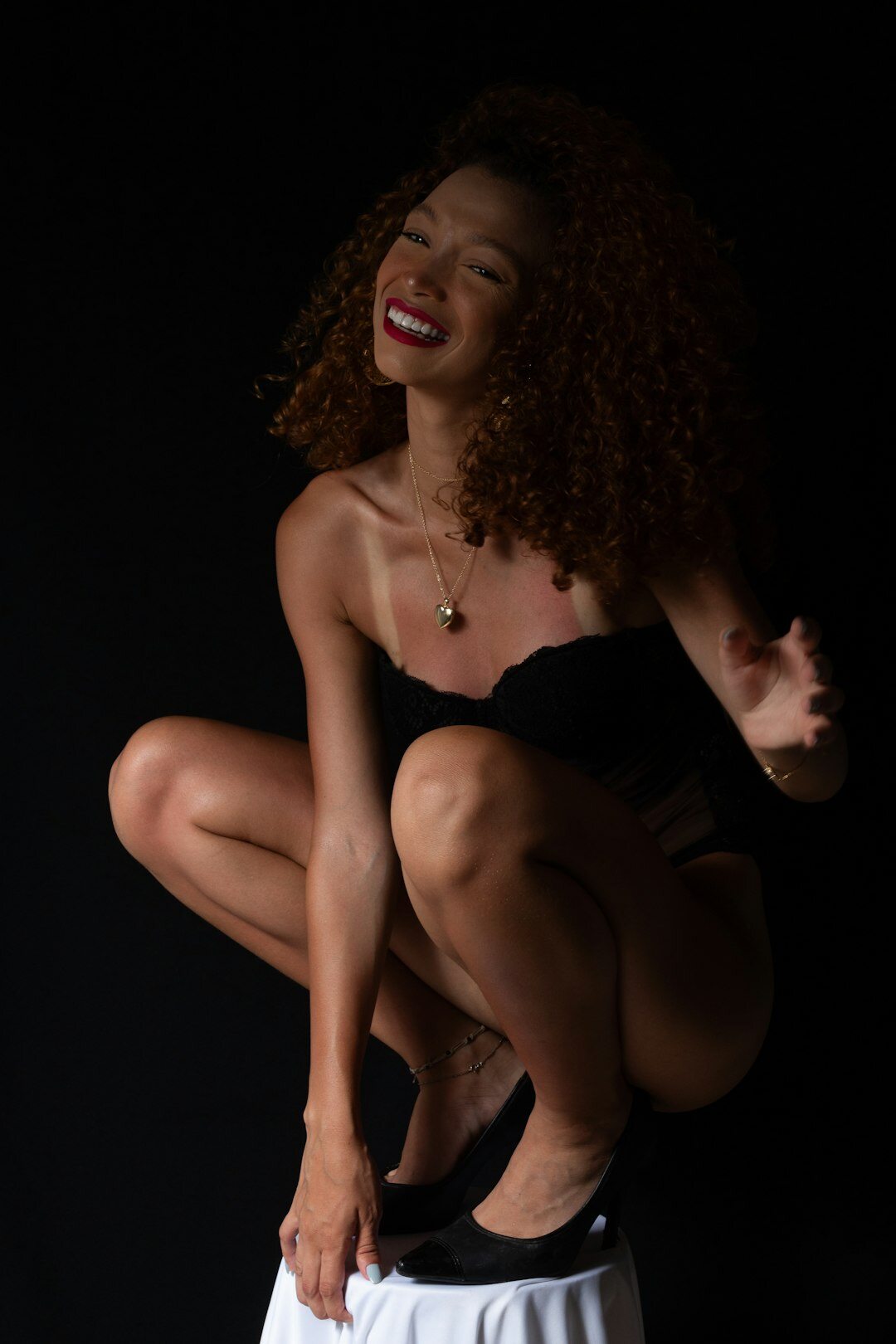 Studio portrait of a Brazilian woman with curly hair smiling